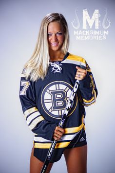 a female hockey player is posing for a photo in her uniform and holding a stick