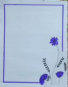 a piece of paper with purple flowers on it and blue trim around the edges, sitting on a table