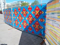 there is a fence that has been decorated with many different colors and designs on it