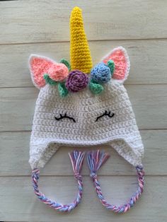 a crocheted unicorn hat with flowers on it