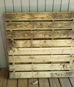 a wooden pallet sitting on top of a wooden floor next to a white wall