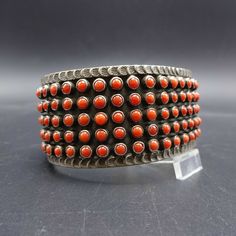 "MATTHEW CHARLEY (NAVAJO) CORAL BRACELET DESCRIPTION: This extraordinary cuff is from trending Navajo artisan Matthew Charley. Snake eye petit point specimens of old red Mediterranean coral are set in heavy gauge hand-stamped sterling. This exceptional bracelet will be a cherished addition to your collection of fine vintage Native American jewelry. MEASUREMENTS: Interior of the cuff measures 5 1/2\" with an additional 1 1/4\" non-adjustable gap. Total circumference: 6 3/4\" Measures 2 3/8\" stra Red Southwestern Cuff Bracelet Gift, Red Southwestern Cuff Bracelet As Gift, Red Vintage Bracelets For Festivals, Vintage Red Bracelets For Festival, Red Cuff Bangle For Festival, Red Cuff Bangle Bracelet For Festival, Red Bangle Cuff Bracelet For Festival, Handmade Southwestern Red Cuff Bracelet, Handmade Red Southwestern Cuff Bracelet