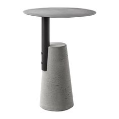 the table is made out of concrete and has a black metal base with a round top