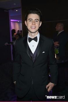 a young man in a tuxedo smiles for the camera at an awards event