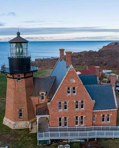 an aerial view of a red brick building with a light house next to the ocean