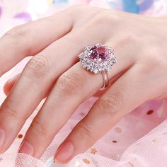 a woman's hand with a pink diamond ring on it