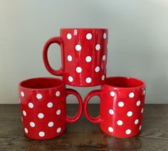 four red and white polka dot mugs stacked on top of each other