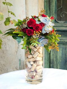 a vase filled with flowers and rocks on top of a table