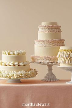 there are many different types of cakes on the table and one is white with pink ruffles