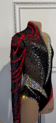 a mannequin wearing a black and red top with sequins on it