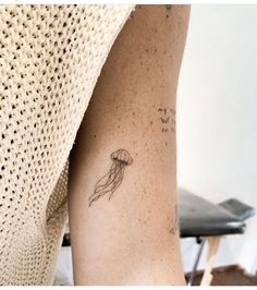 a small jellyfish tattoo on the arm