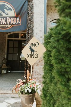 there is a sign that says dino xing in front of a building with plants