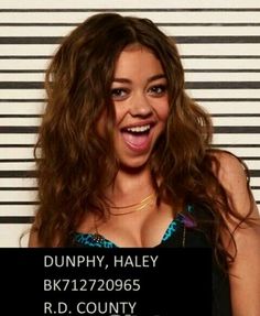 a woman with long hair is smiling in front of a wall that says dunphy, haley