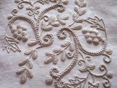 an embroidered piece of cloth with flowers and leaves on it