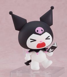 a black and white cat figurine holding a cell phone