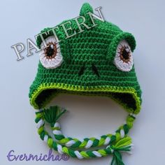 a crocheted frog hat with eyes and braids