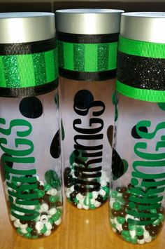 two plastic cups with green and black designs on the lids are sitting next to each other