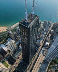 an aerial view of the skyscrapers in new york city, with construction cranes on top