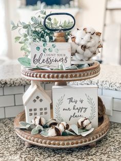 three tiered trays with cotton flowers and signs on them