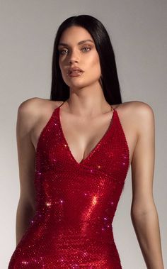 a woman wearing a red dress with sequins on it