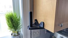 a potted plant sitting on top of a window sill next to a stove