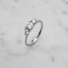 a three stone diamond ring on a marble surface