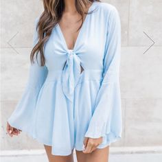 *Never Worn - Brand New Out Of The Packaging, Not In Original Packaging* This Romper Will Be Your New Weekend Favorite! We Love The Classic Light Blue Color With A Tie Front Detail. This Romper Also Features Bell Sleeves It's Such A Cute Detail. Pair It With Wedges And A Floppy Sun Hat For Your Next Beach Getaway! Flowy Romper Style Wears Like A Dress With Shorts - 100% Rayon - Lining 100% Polyester - Hand Wash Cold / Dry Flat Fitted Light Blue Jumpsuits And Rompers For Day Out, Summer Long Sleeve Flirty Jumpsuit, Fitted Light Blue Jumpsuits And Rompers For Spring, Fitted Light Blue Jumpsuit For Spring, Chic Light Blue V-neck Jumpsuit, Blue Jumpsuits And Rompers For Spring Loungewear, Light Blue V-neck Jumpsuit For Party, Spring Long Sleeve Solid Color Jumpsuits And Rompers, Light Blue Fitted V-neck Jumpsuits And Rompers