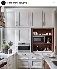 a kitchen with white cabinets and wood flooring is pictured in this image, there are two microwaves on the left side of the cabinet