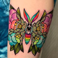 a colorful butterfly tattoo on the arm