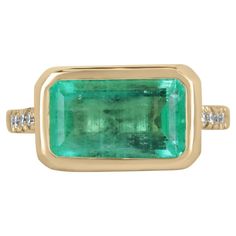 Featuring a one of a kind emerald and diamond ring. This remarkable piece features a large emerald cut emerald from the best mines in the world, Colombia. The gemstone showcases an enthralling spring green color that is vivacious and lustrous all in one with a tint of yellow-green hue. Securely bezel set for the outermost best protection, with brilliant round cut diamonds pave-set within the gold shank to accent perfectly. Crafted in durable, and solid 14K yellow gold. Setting Style: Bezel/Pave Spring Green Color, East West Ring, Emerald And Diamond Ring, Light Spring, Yellow Gold Setting, Pave Setting, Emerald Cut Diamonds, East West, Spring Green