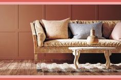 a couch and table in a room with wood paneling on the wall behind it