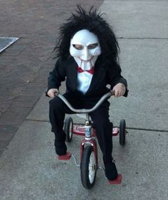 a child's tricycle with a creepy mask on it