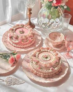 a table topped with pink plates covered in frosting next to a vase filled with flowers