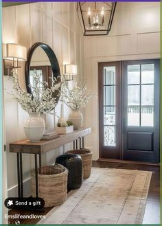 an entryway with two vases on the table and a mirror hanging above it