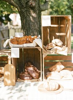 breads and pastries are on display under a tree