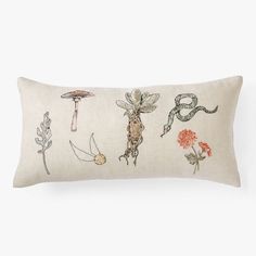 an embroidered pillow with different types of flowers and plants on the front, along with a white background