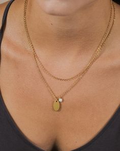 Add dainty details to your favorite looks with this layered piece! It features a smooth disk charm and a glam opal charm. This necklace is available in gold and silver tones. Materials: 14K gold or rhodium plated brass, created opal Features: Measures 16-18" with 2" extender, 0.35" & 0.75" pendants, 5mm opal stone, 2mm chain, Lead & Nickel free, lobster clasp Gold Layered Necklace With Pearl Pendant, Gold Charm Necklace With Pearl For Layering, Gold Pearl Charm Necklace For Layering, Dainty Gold Layered Charm Necklaces, Charm Necklace With Delicate Chain And Round Pendant, Delicate Round Charm Necklaces For Layering, Chain Layered Necklace, Pearl Chain Necklace, Figaro Chain Necklace