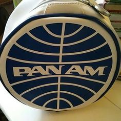 the pan am logo is on top of a white and blue bag with a chain hanging from it's side