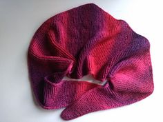 a pink and purple scarf laying on top of a white table