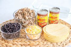 an assortment of canned food items on a woven place mat, including cornbreads, black beans and tortillas