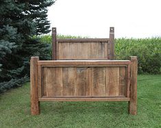 a wooden bed frame sitting in the grass