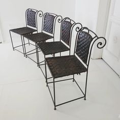 four chairs sitting next to each other on top of a white floor in front of a door