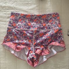 Free People Pli All Day Ruffle Lounge Active Yoga Shorts Stretch Multicolor Floral Print Shorts, Multicolor Stretch Floral Print Shorts, Stretch Ruffle Shorts For Loungewear, Stretch Ruffled Shorts For Loungewear, Pink Ruffled Shorts For Loungewear, Pink Ruffled Shorts For Beach, Multicolor Ruffled Bottoms For Beach, Pink Stretch Ruffle Shorts, Stretch Pink Ruffled Shorts