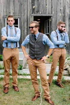 three men wearing ties and vests standing in front of a barn with their hands on their hips