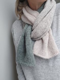 a woman wearing a gray sweater and grey scarf