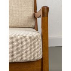 a close up of a wooden chair with fabric on the armrests and back