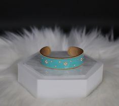 The Turquoise Cuff Bracelet boasts a captivating design with vibrant turquoise stones intricately embedded in a sleek cuff. This accessory effortlessly combines a pop of color with a chic and versatile style, making it a statement piece for any fashion ensemble. Size: 6 3/4 inches - Inner Diameter Closure: Bangle Hinge Bracelet Material: Brass with 18K Gold Plating with Rhodium Coating Lead Free and Hypoallergenic Elegant Turquoise Cuff Bracelet, Trendy Turquoise Bangle Jewelry, Turquoise Bracelet Jewelry, Turquoise Bracelet Fashion Accessory, Turquoise Fashion Bracelet, Elegant Turquoise Bracelets, Hinge Bracelet, Edgy Aesthetic, Turquoise Bracelet Cuff