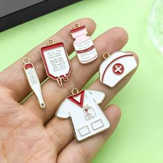 a person holding four different shaped pins in their hand, one with a nurse's stethoscope and the other with a doctor's name on it