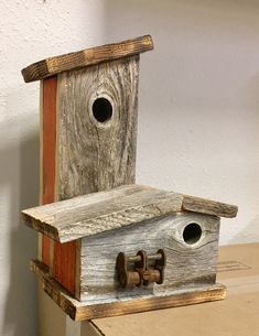 a birdhouse made out of wood with two holes in the roof