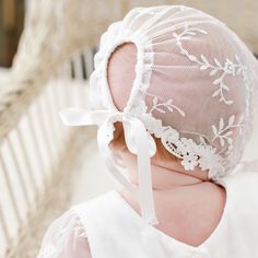 a close up of a baby wearing a bonnet